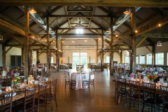 large room with post and beam vaulted ceiling and long rectangular wood tables.