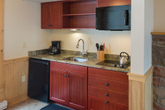 Kitchenette with wooden cabinets and modern kitchen appliances at Mountain Top Inn & Resort in Chittenden, VT