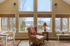photograph of cloud nine guest home view from the living room. all the window blinds are lifted and show a mountain view in March. 