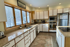deer run kitchen featuring a fridge, oven, microwave, and island.