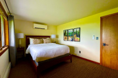 deer run guest home bedroom on the lower level with three photos on the wall.