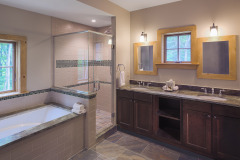 oversized bathroom with large soaking tub beside walk-in glass shower and double vanity.