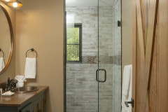 Upstairs Bedroom 2 En-Suite Bathroom Interior, with stone-designed shower space and wooden vanity.
