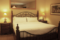 Mountain Top Resort Grand Vista Guest House wrought iron king bed with white bedding.