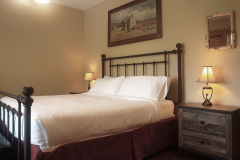 Mountain Top Resort Grand Vista Guest House wrought iron bed with white bedding.