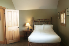 Mountain Top Resort Grand Vista Guest House bedroom with wooden log bed and white bedding.