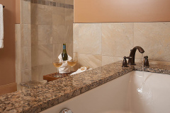 Mountain Top Resort Grand Vista Guest House jetted soaking tub with granite border and champagne bottle with glasses on edge.