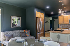 close up of dining area with seating area behind them with the kitchen.