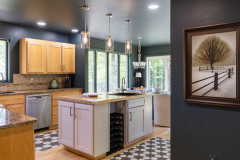 view of kitchen from hallway showcasing the island and windows in the background. 