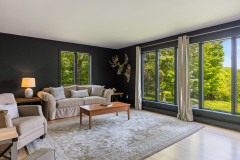 Living Room featuring large floor to ceiling windows with a view, a couch, coffee table, and rug. 