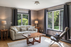 secondary living room with sofa, reclined chair, and coffee table. 