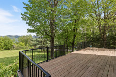 view from the deck showing black railing around deck and mountainscapes in the background. 
