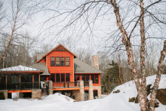 exterior of guest home with large glass windows in the winter