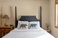 bedroom one in pondview guest home. headboard is black and features two pillows with black bears on them.