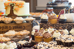 table laden with cupcakes and cakes on wooden crates.
