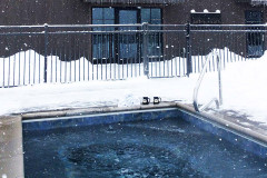 In-ground hot tub surrounded by snow.