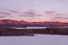 violet hued sunset view over snow covered mountains.