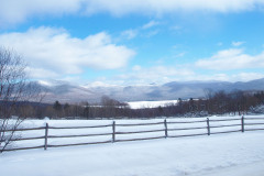 Split rail fence along snow covered field.