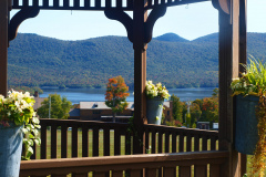 Wooden gazebo with flower pots with flowers on top of railing overlooking lake and mountains at Mountain Top Inn & Resort in Chittenden, VT
