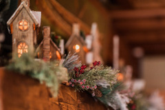 Small wooden toy houses with floral arrangements on top of mantle at Mountain Top Inn & Resort in Chittenden, VT