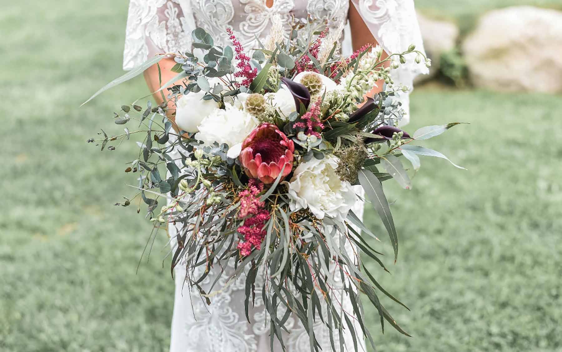 bride in a white gown holding extravagant bouquet