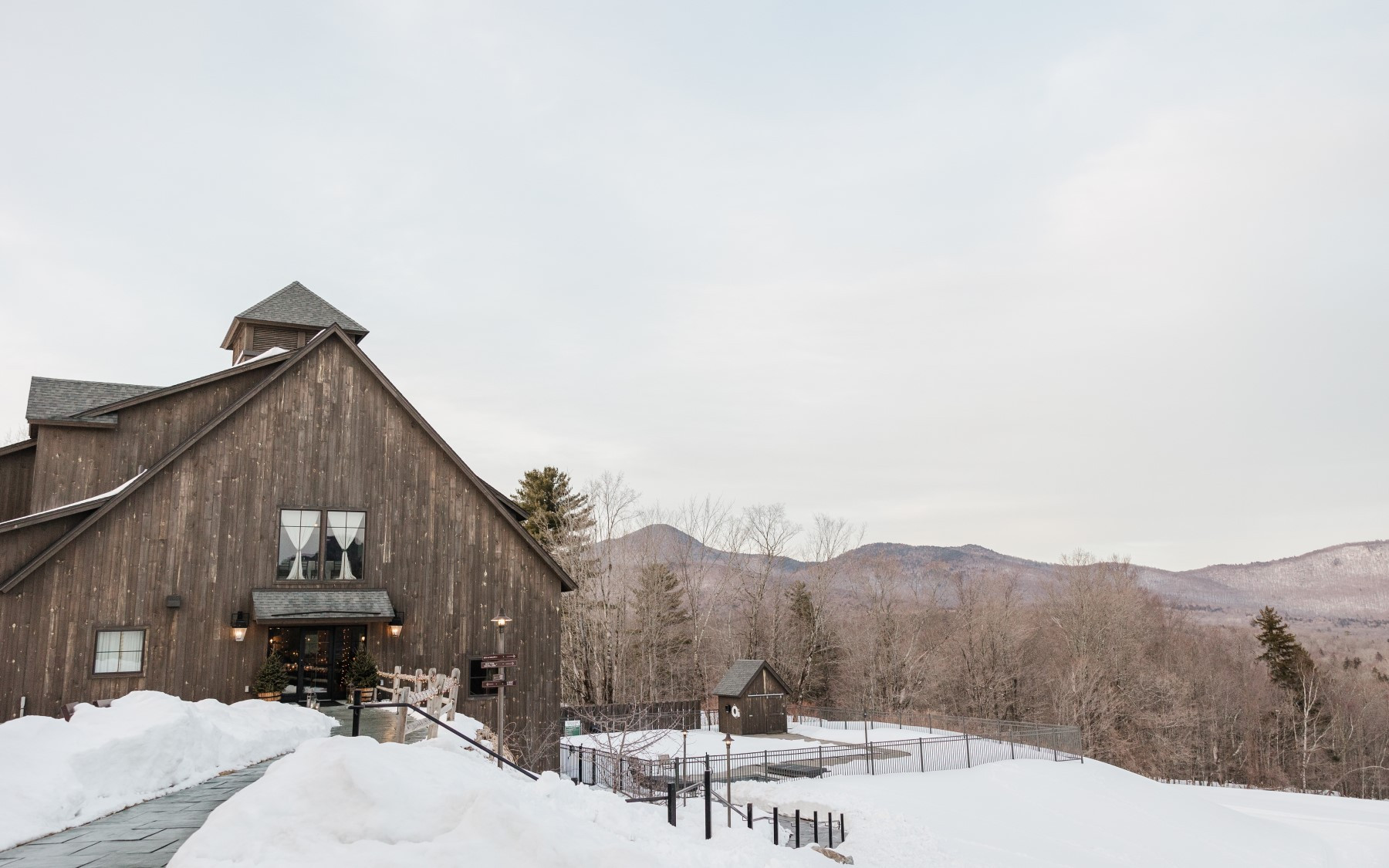 Event barn in the winter featuring a covered pool to the left, overlooking a mountain scene