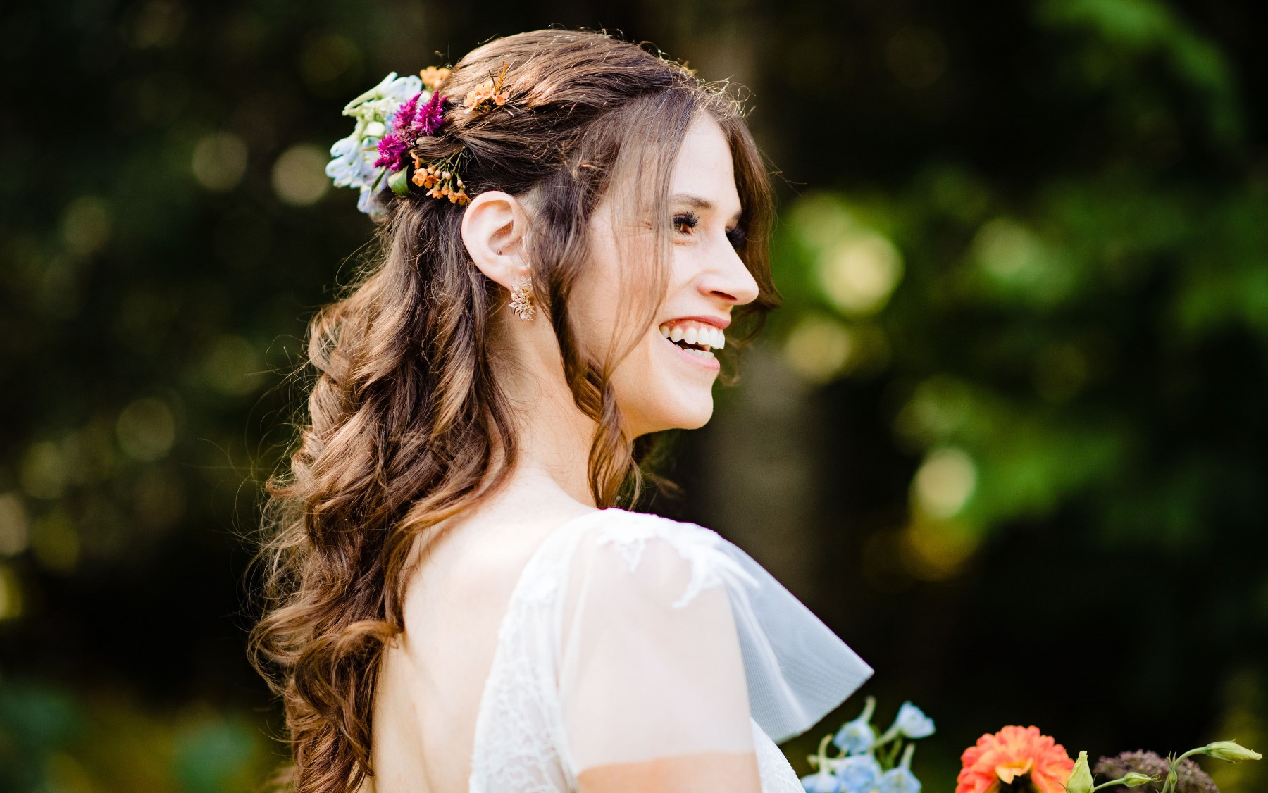floral pieces in hair for wedding day with bride smiling