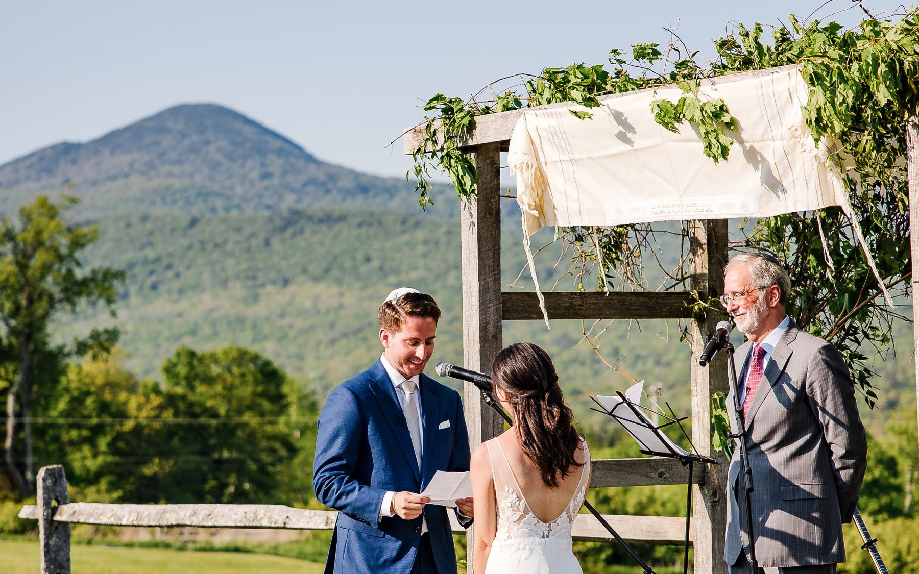 wedding knoll featuring bride and groom exchanging vows overlooking Green mountains.