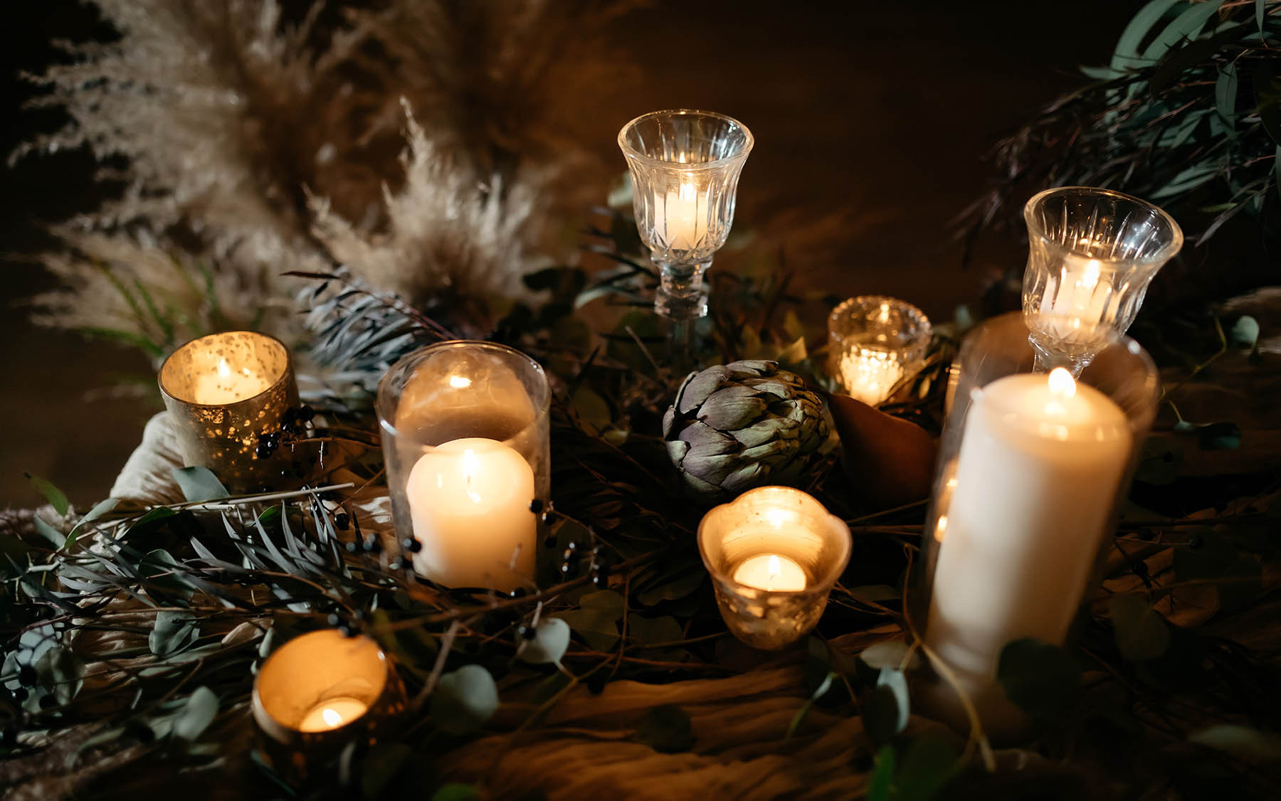 candles and greenery on table.