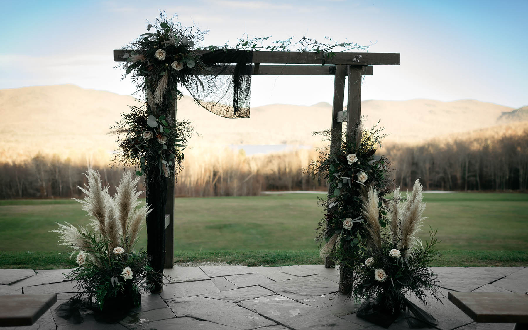 patio with arbor and floral decor, mountains in background.