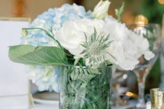 Blue and white flowers in a glass vase on a table.