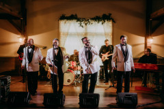 band in white blazers performing during a wedding reception.