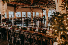 event barn featuring farmhouse tables, chivari chairs, and string lights.