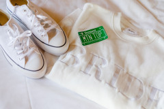 bride sweatshirt in white with a pair of sneakers and a green sticker saying \"MTN TOP\"