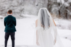 bride walking towards groom with backs facing camera
