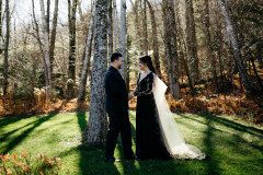 Couple in black formal wear in autumn woods.