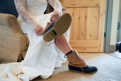detail shot of bride putting on winter boots for her wedding