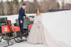 bride and groom stepping out of horse-drawn sleigh in winter