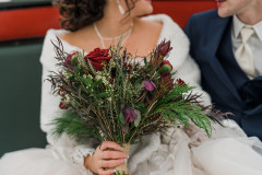 close up of floral bouquet featuring red and green designs