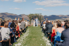 wedding knoll with petals on ground next to farmhouse benches leading to knoll overlooking Green Mountains