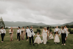 wedding couple walking with wedding party towards camera. 