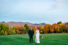 bride and groom walking towards camera with mountains in background.