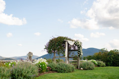 photo of weddng arbor featuring florals and drapes with a mountainscape behind it,