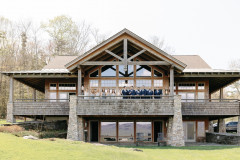 photo of guest house, the jewel, with bride and grooms and wedding party on second floor deck overlooking the meadow.