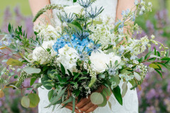 close up of floral bouquet featuring white, blue and green floral designs