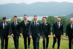 groomsmen walking towards camera with mountains in background