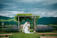 bride and groom kissing at wedding knoll in summer time.