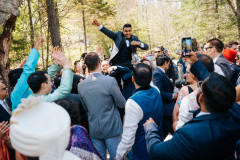 groom being held up by family as part of traditional Indian wedding.