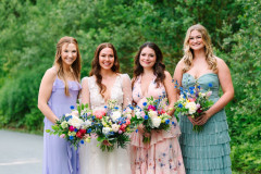 bride with three bridesmaids with floral bouquets.