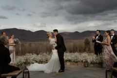 bride and groom after vows standing on terrace with florals behind them